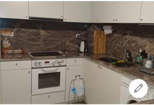 a kitchen with white cabinets and a stove top oven at Cozy Room with Sea View in Athens