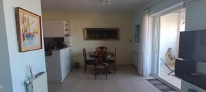 a kitchen and dining room with a table and chairs at Cozy Room with Sea View in Athens