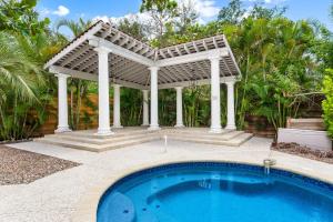 a pergola over a swimming pool in a backyard at Crescent Beach Villas in Siesta Key