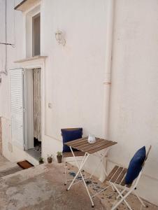 une table et deux chaises assises à côté d'un bâtiment dans l'établissement La Casa Shabby Chic, à Matino