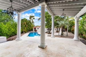an outdoor patio with a large pergola and a swimming pool at Crescent Beach Villas in Siesta Key