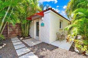 a small white cottage with palm trees in front of it at Crescent Beach Villas in Siesta Key