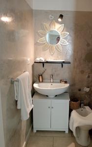 La salle de bains est pourvue d'un lavabo, d'un miroir et de toilettes. dans l'établissement La Casa Shabby Chic, à Matino