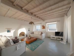 una sala de estar con un sofá y una mesa en Villa Prive 77 Mykonos, en Mykonos ciudad