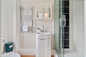 a white bathroom with a sink and a shower at The Pondmore-Spacious Detached house in Ashford with free parking close to M20 in Kent +19 photos