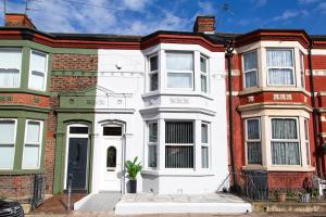 a white house with a potted plant in front of it at 4 Bedrooms Spacious House With 2 Bathrooms Free Parking - sleeps up to 10 guests in Liverpool