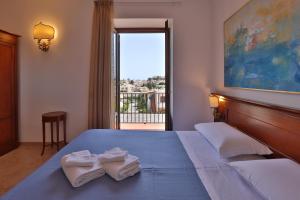 1 dormitorio con 1 cama grande y toallas. en Hotel Villa Cute - HVC en Lipari