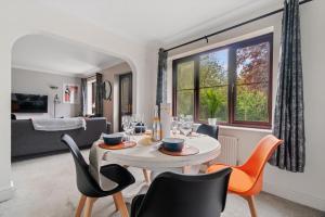 a dining room with a table and chairs and a window at The Pondmore-Spacious Detached house in Ashford with free parking close to M20 in Kent
