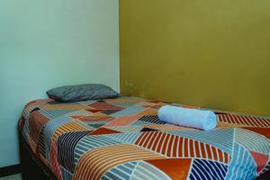 a bed with a colorful comforter in a room at Sumanas Homestay Ijen in Banyuwangi