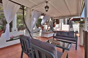 a porch with a couch and a table and chairs at Hotel Villa Cute - HVC in Lipari