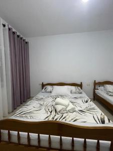a bedroom with a large bed with white sheets at Klevi Apartments in Golem