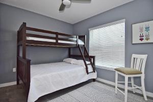 a bedroom with two bunk beds and a chair at Family Tides in Siesta Key