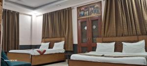 2 bedden in een hotelkamer met gordijnen bij Angel Pink Residency B58 in Ghaziabad