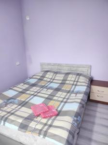 a bed with two pink slippers on top of it at Asian Guest House in Bishkek