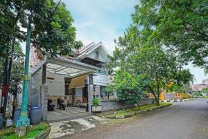 un bâtiment avec une moto garée à côté d'une rue dans l'établissement Mitra Dago Antapani Syariah, à Bandung