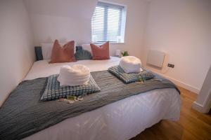 a bedroom with a bed with two towels on it at Cozy Living in Abbey Woods in Abbey Wood