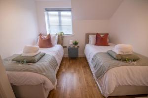 um quarto com duas camas com almofadas em Cozy Living in Abbey Woods em Abbey Wood