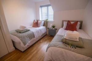 um quarto com duas camas e uma janela. em Cozy Living in Abbey Woods em Abbey Wood