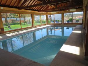 einen Pool in einem Haus mit Glasfenstern in der Unterkunft Villa - Casa Grande de Arcos in Arcos