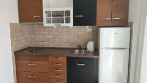 a kitchen with a white refrigerator and a sink at Mazuran2 in Hvar +4 photos