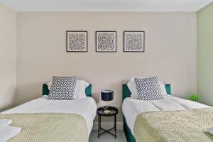 two beds sitting next to each other in a room at The Pondmore-Spacious Detached house in Ashford with free parking close to M20 in Kent