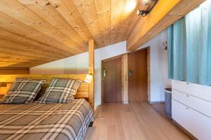 una camera con letto e soffitto in legno di Appartement Les Genevriers a Le Grand-Bornand