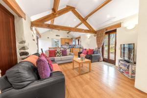 a living room with a leather couch and a table at Damson Cottage in Waberthwaite