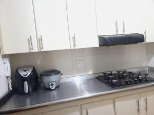 a kitchen counter with a stove and a toaster at Bello y amplio apartamento cerca al aeropuerto in Pereira +9 photos