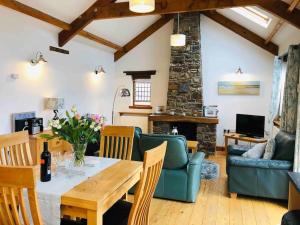 a living room with a table and a couch at Stables A delightful one bed cottage with parking! in Appledore