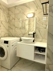 ein weißes Badezimmer mit einer Waschmaschine und einem Waschbecken in der Unterkunft Walk into Dream of Acropolis 10 in Athen