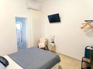 um quarto com uma cama e uma televisão na parede em MAR ROSA, estacionamento gratuito na Nazaré