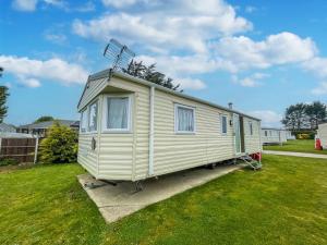 ein winziges Haus steht in einem Hof in der Unterkunft Great Caravan At Breydon Water Holiday Park, Ref 10086b in Belton