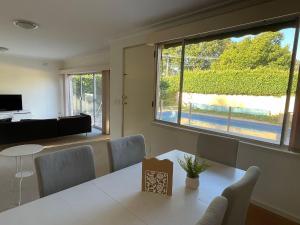 ein Esszimmer mit einem Tisch und einem großen Fenster in der Unterkunft Home in Brighton in Melbourne