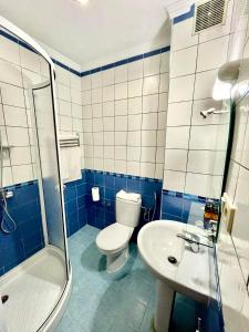 La salle de bains bleue et blanche est pourvue de toilettes et d'un lavabo. dans l'établissement Sary's Hotel, à M'diq
