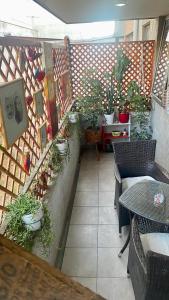 un patio con mesa, sillas y macetas en Jardines, en Santiago
