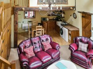 a living room with two leather chairs and a table at Lilac Barn in Newton Reigny