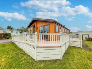 a tiny house on a deck in a yard at Beautiful 6 Berth Lodge With Disabled Access At Cherry Tree Ref 70829c in Great Yarmouth