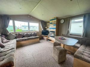 a living room with a couch and a table at Lovely 8 Berth Caravan At California Cliffs Holiday Park In Norfolk Ref 50053c in Great Yarmouth