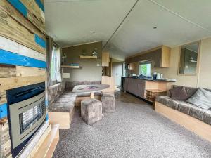 a living room with a couch and a table at Lovely 8 Berth Caravan At California Cliffs Holiday Park In Norfolk Ref 50053c in Great Yarmouth