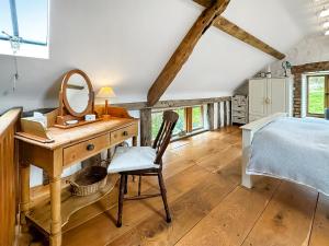 a bedroom with a desk and a bed and a mirror at Meadow Barn in Shelve