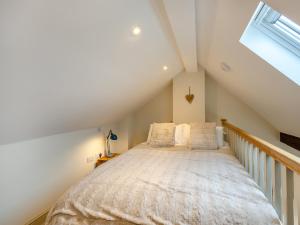 una camera da letto con un grande letto in mansarda di Wisteria Cottage - Uk46478 a Hemingby