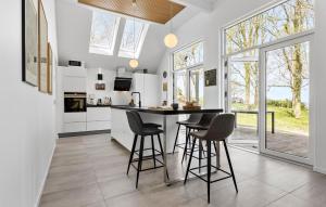 uma cozinha com um balcão e bancos num quarto com janelas em Cozy Home In Asperup With Kitchen em Asperup