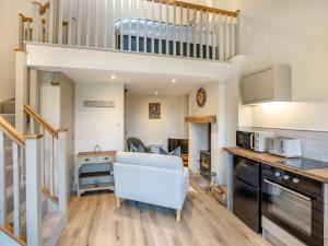 una cucina e un soggiorno con divano bianco di Wisteria Cottage - Uk46478 a Hemingby