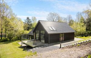 een klein huis met een zwart dak bij Cozy Home In Asperup With Kitchen in Asperup