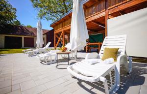 a group of white chairs and umbrellas on a patio at Stunning Home In Ivanska With Outdoor Swimming Pool in Ivanska