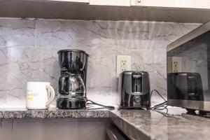 a kitchen counter with a coffee maker and a microwave at Cozy Retreat in Houston Galleria in Houston