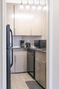 a kitchen with white cabinets and a sink at Cozy Retreat in Houston Galleria in Houston