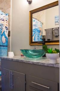 La salle de bains est pourvue d'un lavabo vert et d'un miroir. dans l'établissement Cozy Retreat in Houston Galleria, à Houston