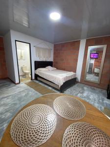 um quarto com uma cama e duas mesas circulares em GREEN APARTMEN "el bosque" em Girón