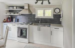 cocina con armarios blancos, fregadero y ventana en Nice Home In Svenljunga With House Sea View, en Svenljunga